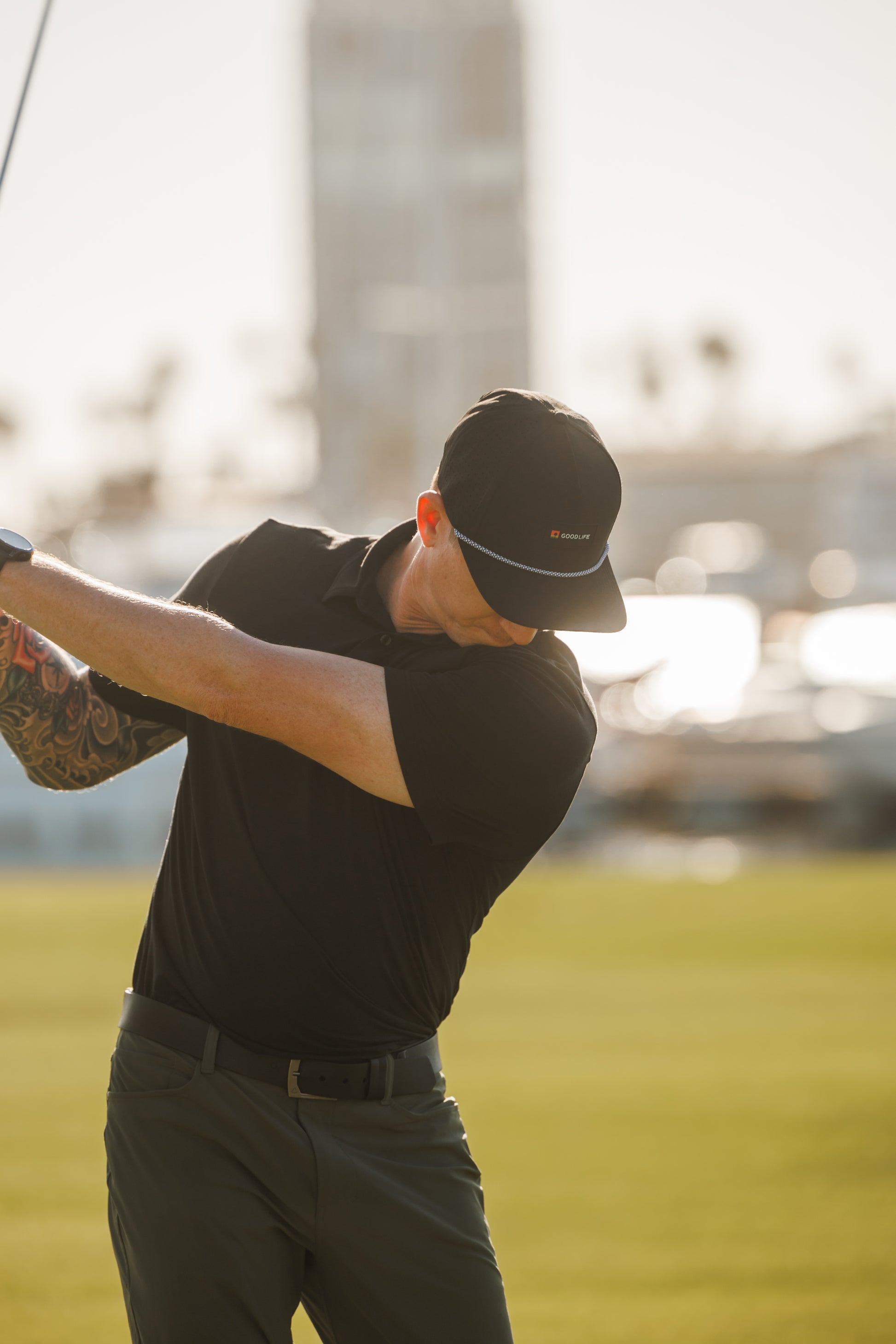 Man swinging a golf club on a golf course with a blurred background